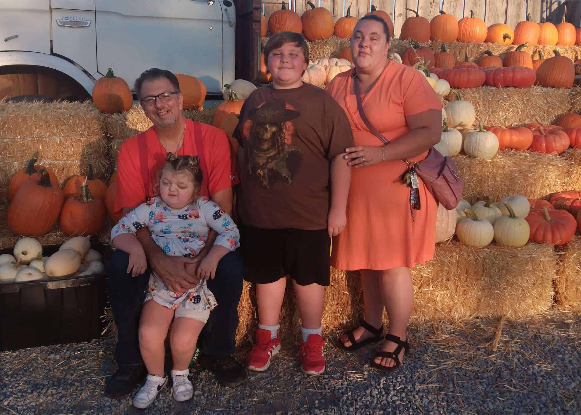 Mom, Dad, brother and four-year-old Zoe in a pumpkin patch
