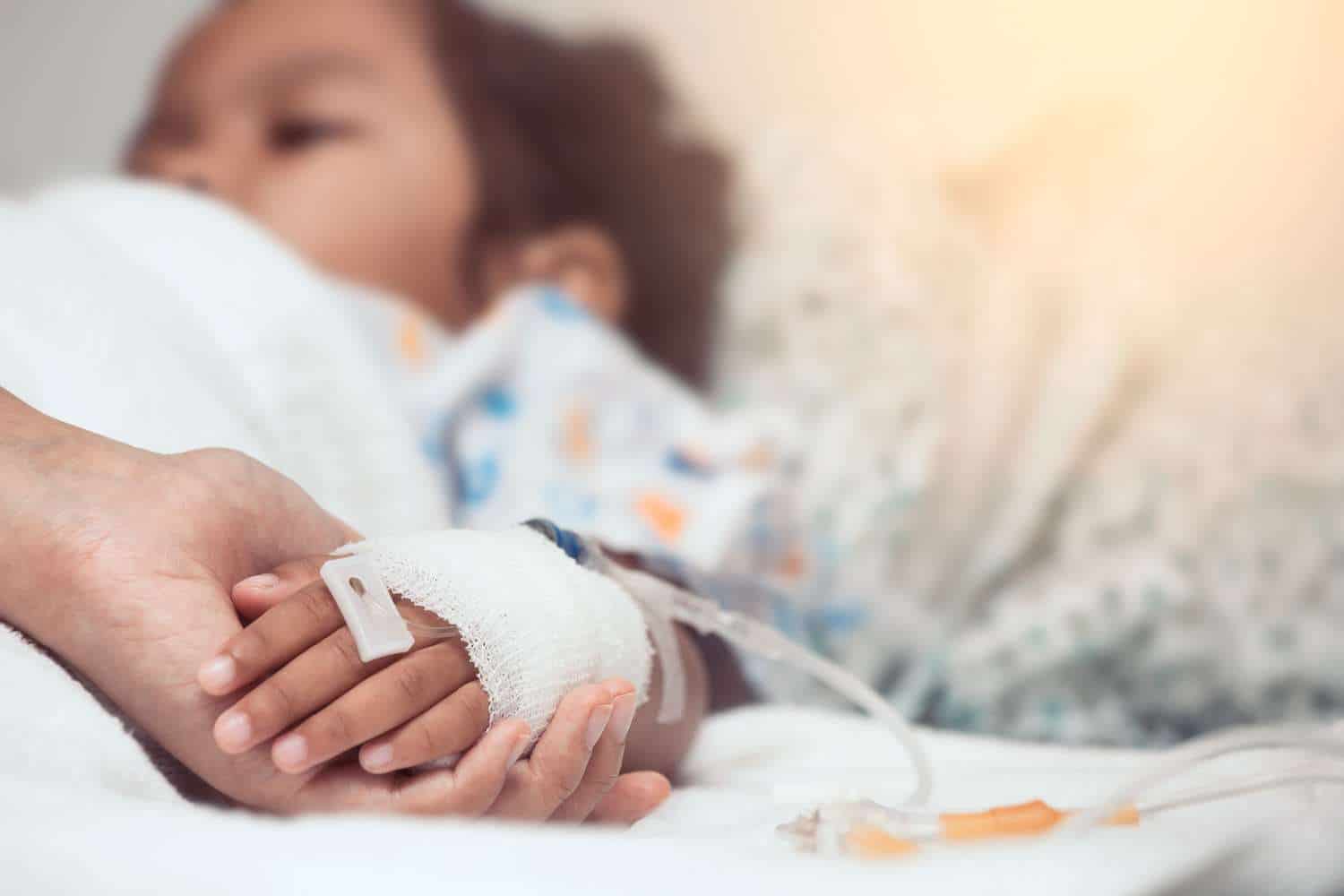 Mother hand holding child hand who have IV solution in the hospital